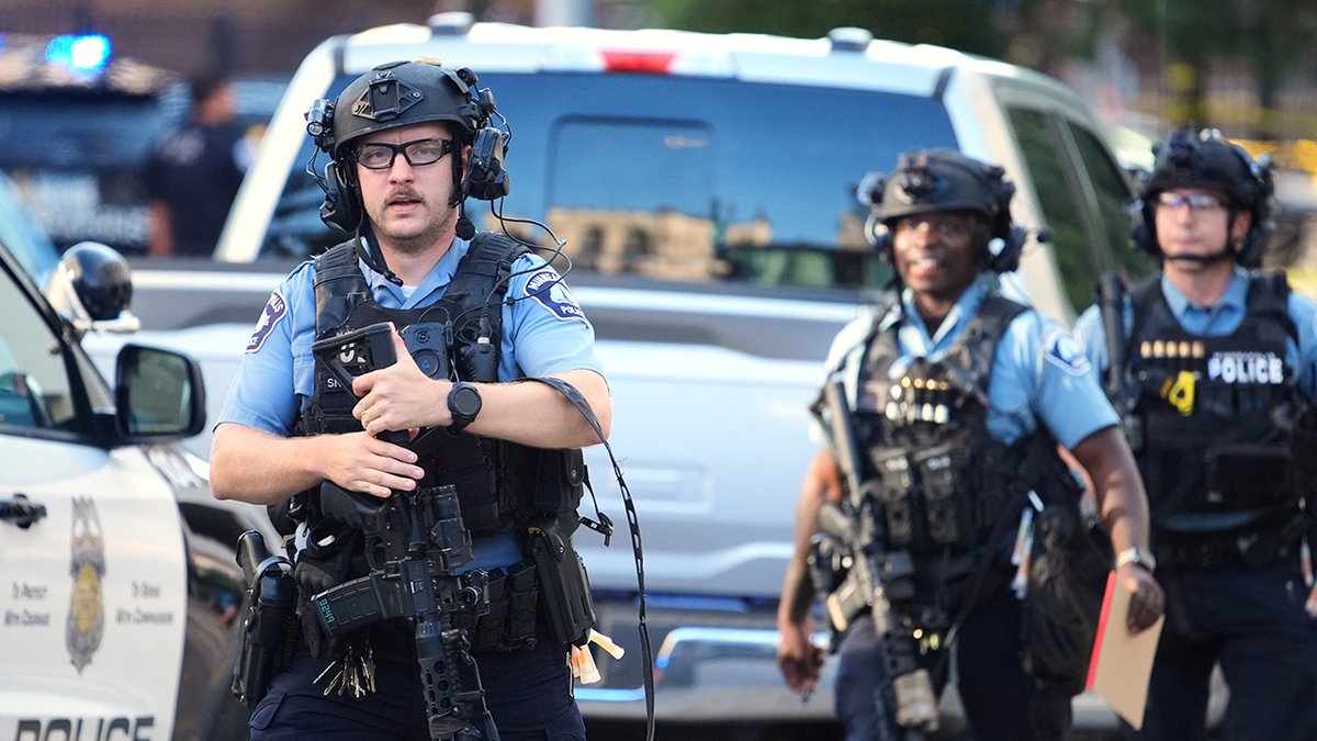 Officers investigate the aftermath of a shooting in Minneapolis on Wednesday.