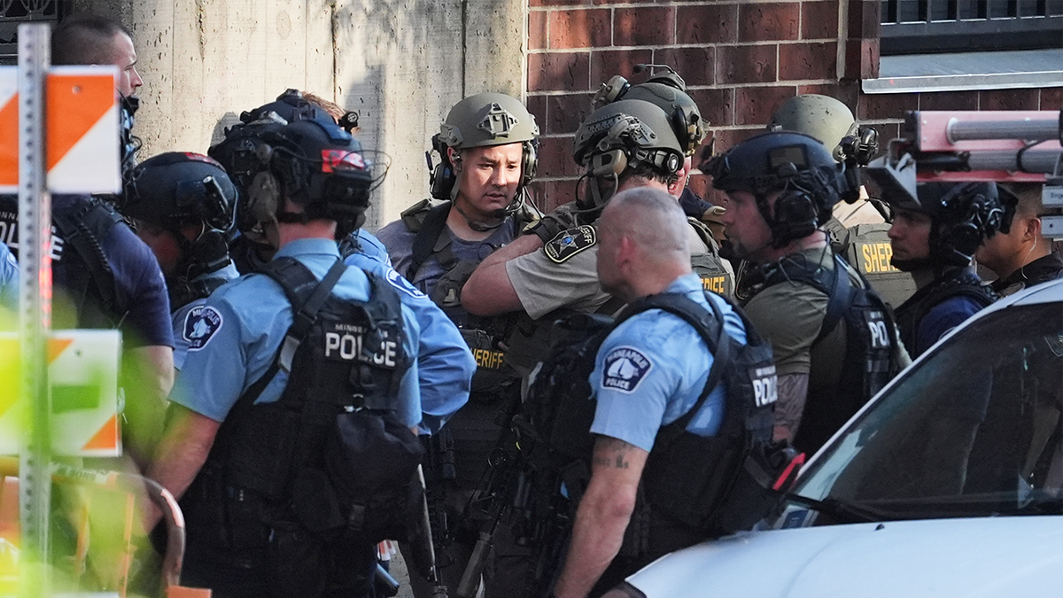 Law enforcement react to the scene of a shooting in Minneapolis on Wednesday.