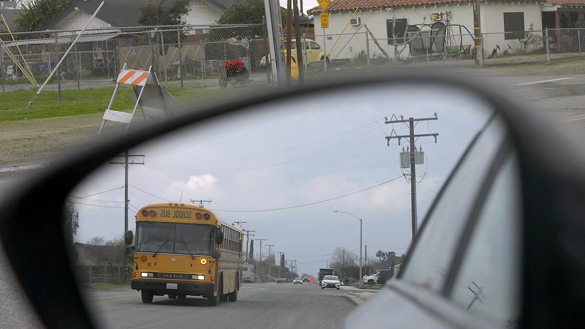 School bus seen from a car mirror.