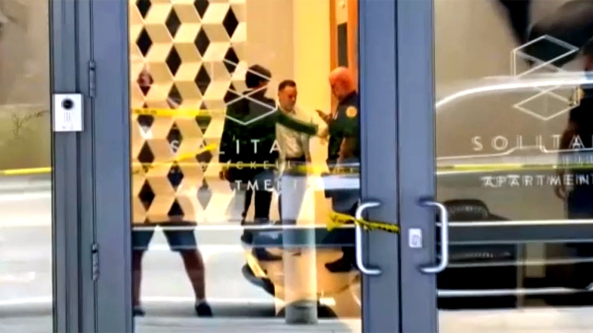 authorities are seen investigating inside the lobby of the building