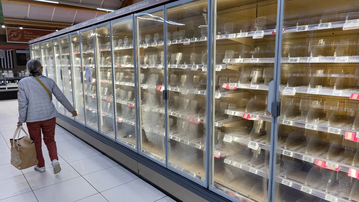 A woman walks past empty fresh-food refrigerators at an Intermarché supermarket in Névez, western France, on October 12, 2026, following a cyberattack affecting the French supermarket chains Intermarché and Cooperative U that caused their refrigerators to defrost. Some 150 to 200 Intermarché stores were targeted in the attack on October 12, 2026, along with nearly 100 Coopérative U outlets, the retailers said. BFM TV reported that rival giant E. Leclerc was also affected, with hackers 