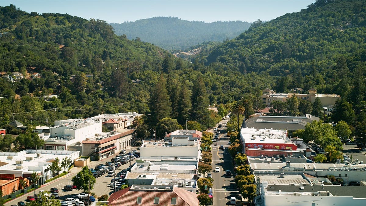 Aerial view of a community surrounded by wooded hills in the Santa Cruz Mountains of California.