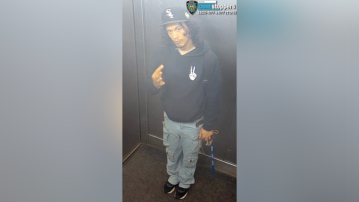 NYPD-released image of Angel Carrasco wearing a black cap and hoodie inside an elevator