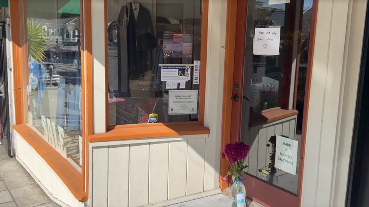 Purple flowers beside a Bryn Walker store entrance with a handwritten closure notice on the door