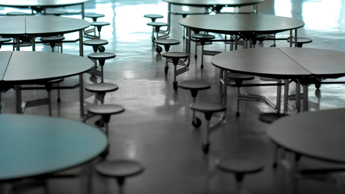 Empty cafeteria with round tables and attached stools