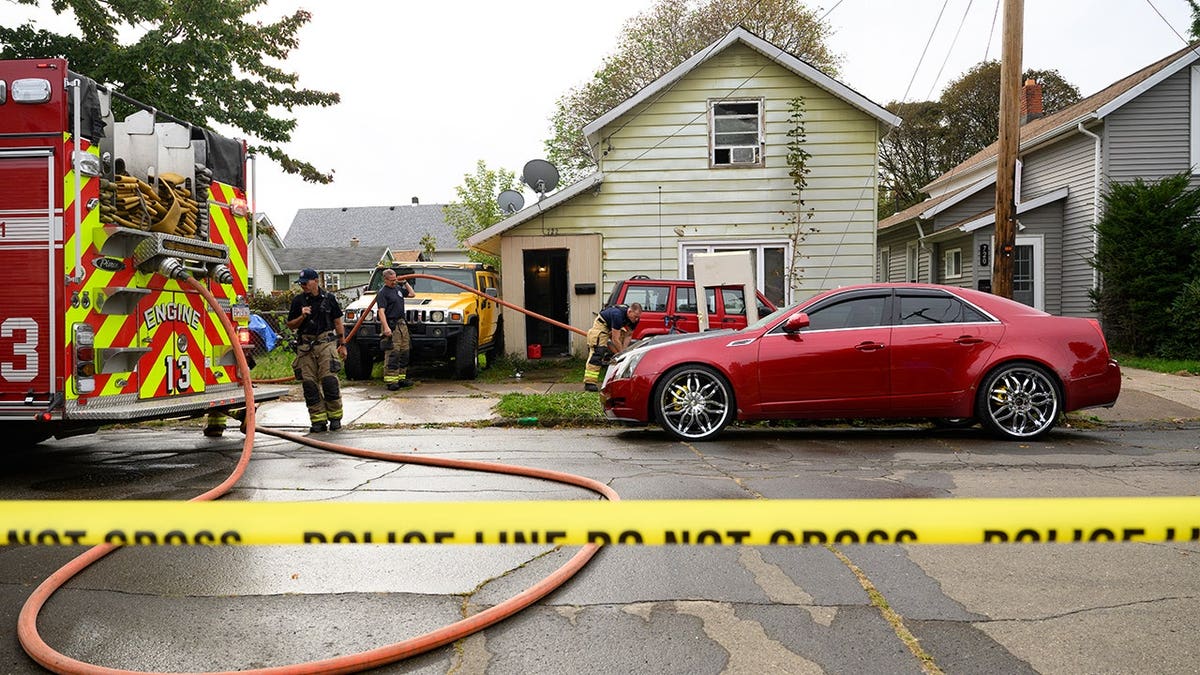 Firefighters clean blood outside a home in Erie, Pennsylvania after a family killing.