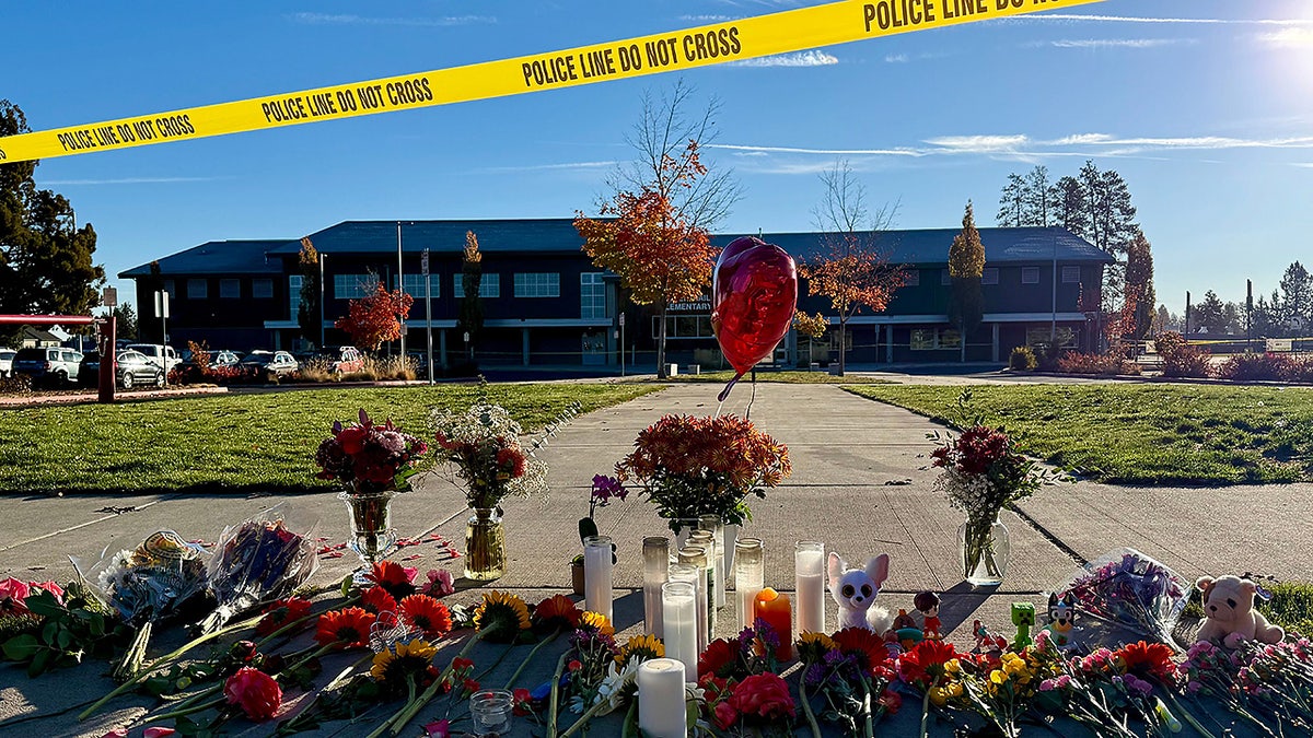 Flowers and candles are placed at a makeshift memorial at Silver Rail Elementary School in Bend, Ore., on Friday, Oct. 16, 2026, a day after a deadly shooting.