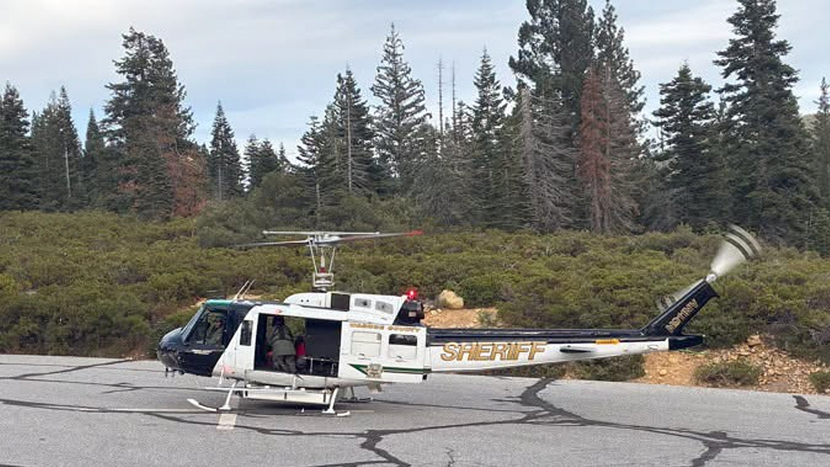 Sheriff’s helicopter sits on a paved landing area surrounded by trees
