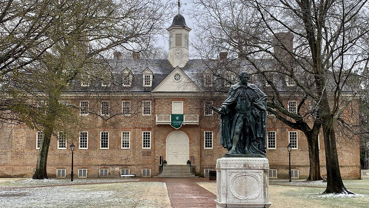 A brick campus building and statue at William & Mary in Williamsburg, Virginia